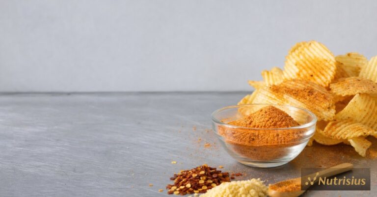 Bumbu tabur keju pedas ditaburkan di atas keripik kentang bergelombang.