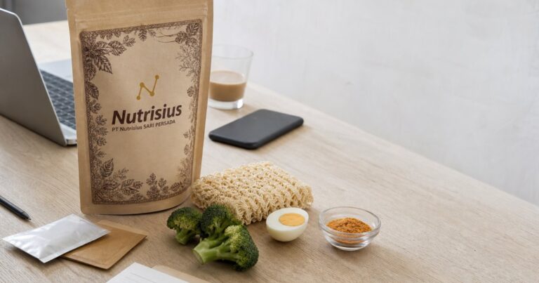 Pouch premix mie instan sehat di meja dengan mie polos, brokoli, telur, dan bumbu.
